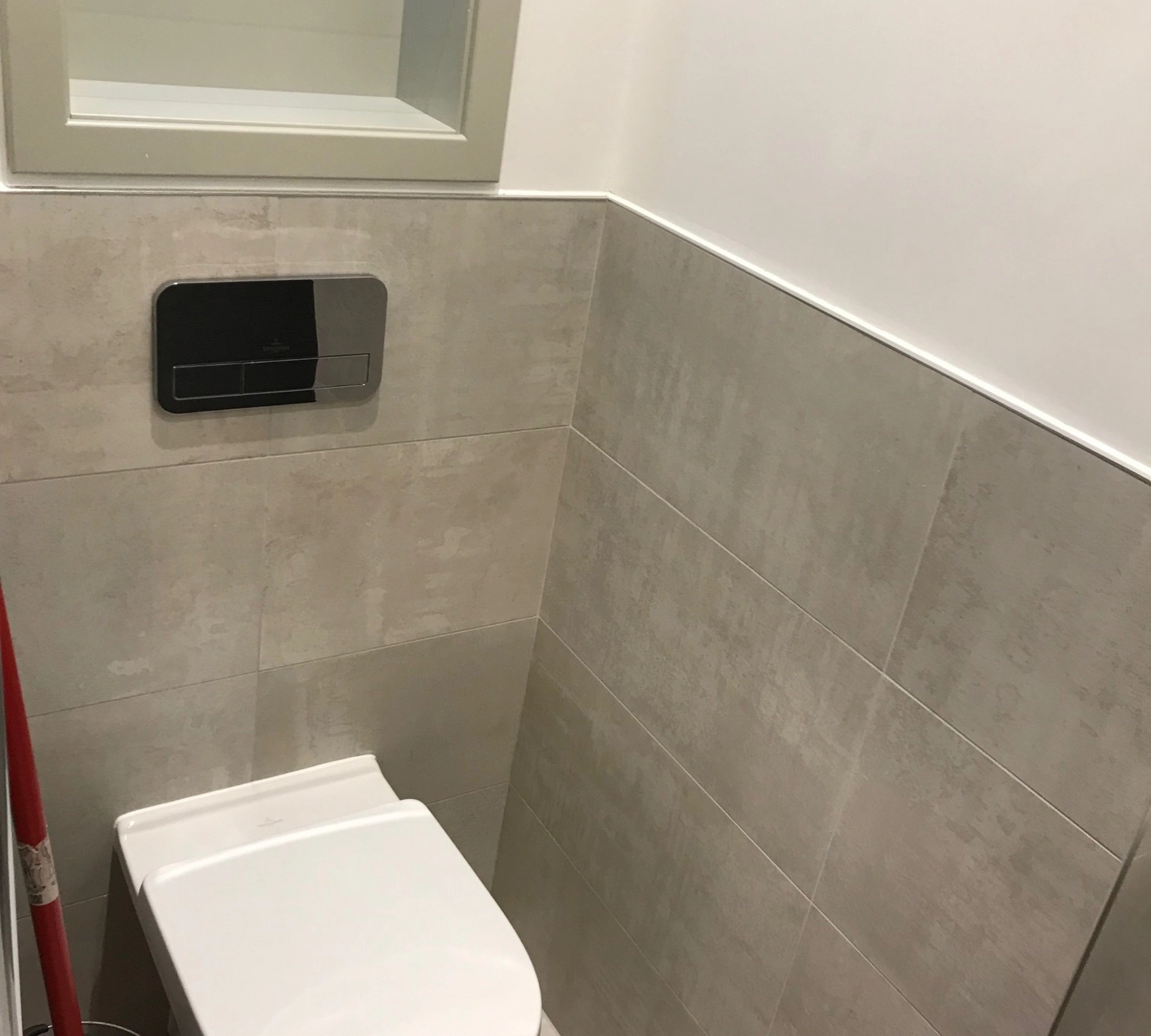 Gray tiled wall with toilet