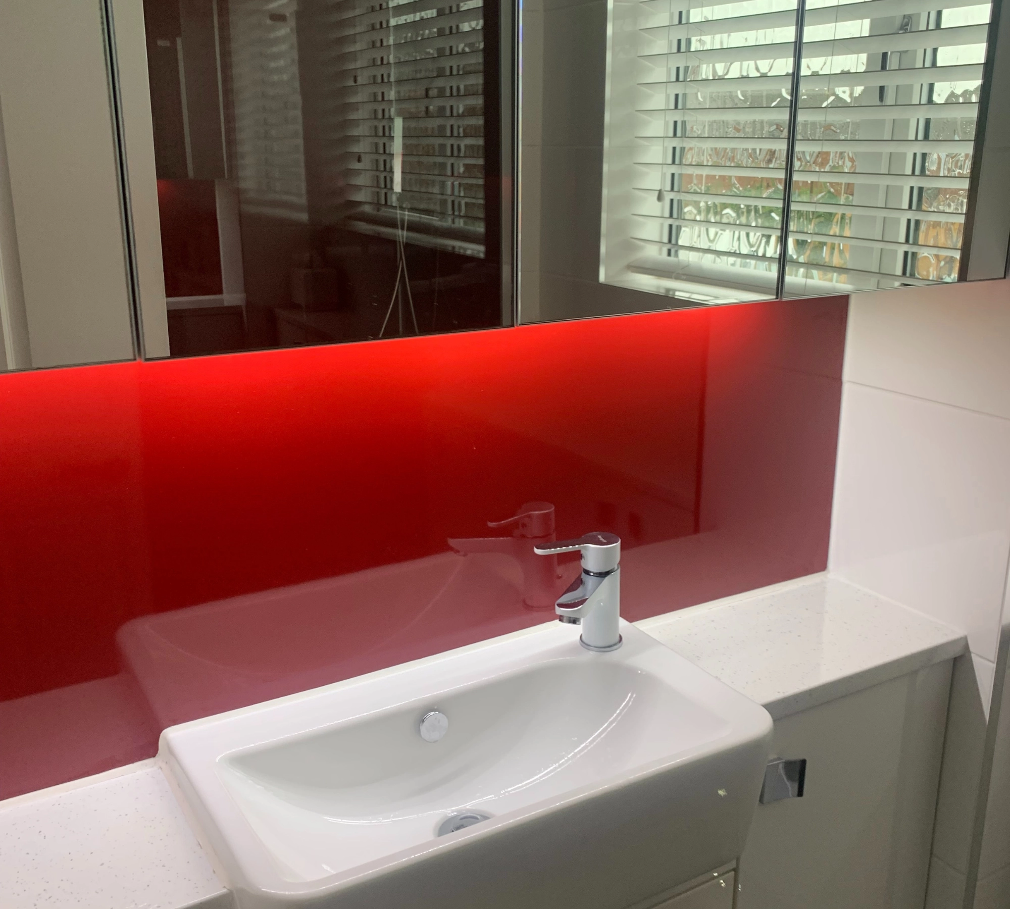 White sink with red glass backsplash